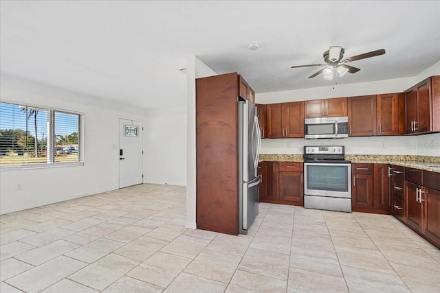 kitchen with ceiling fan, appliances with stainless steel finishes, and light stone counters