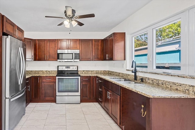 kitchen featuring light stone countertops, ceiling fan, appliances with stainless steel finishes, and sink