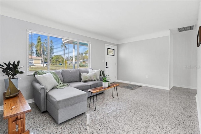 living room with visible vents, speckled floor, and baseboards