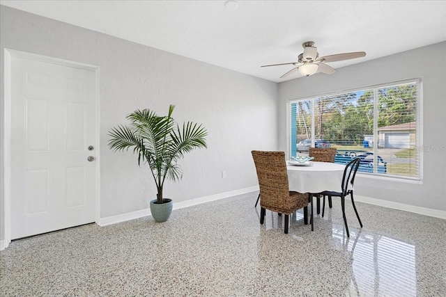 dining area featuring ceiling fan, speckled floor, and baseboards