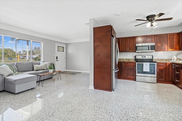 kitchen with stainless steel appliances, light speckled floor, dark brown cabinets, and open floor plan