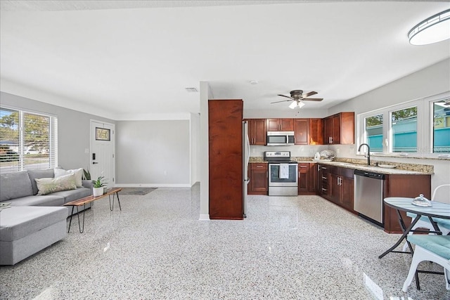 kitchen with a wealth of natural light, stainless steel appliances, baseboards, and open floor plan