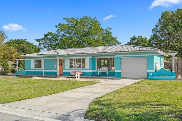 ranch-style house with a tile roof, concrete driveway, a front yard, covered porch, and an attached garage