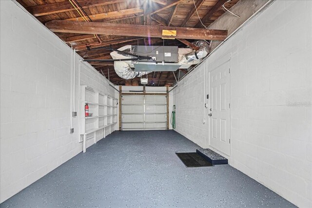 garage with concrete block wall and a garage door opener