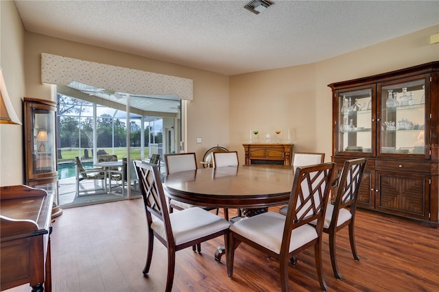 dining room with hardwood / wood-style flooring and a textured ceiling