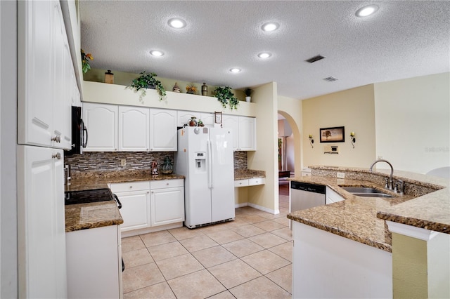 kitchen with white cabinetry, sink, kitchen peninsula, dark stone countertops, and appliances with stainless steel finishes