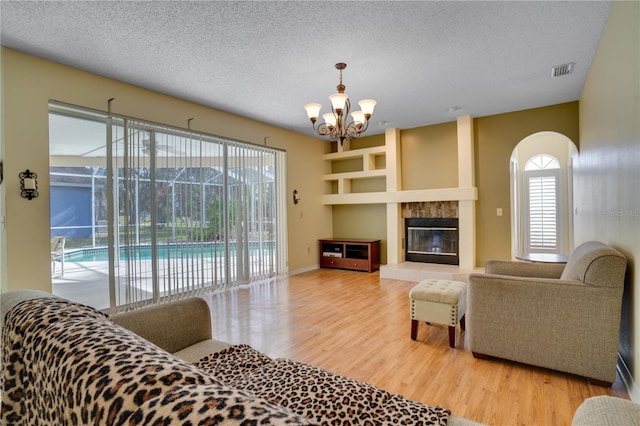 living room with a fireplace, hardwood / wood-style floors, and a textured ceiling