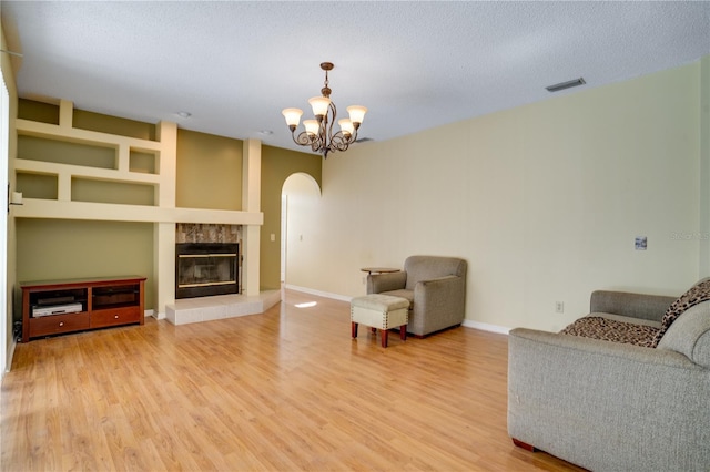 living room with a chandelier, a textured ceiling, and hardwood / wood-style flooring