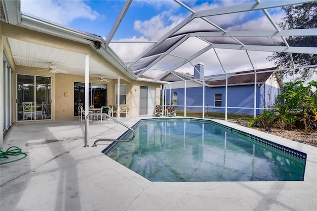 view of swimming pool with ceiling fan, a patio area, and glass enclosure