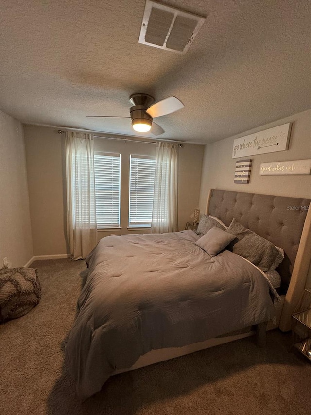 carpeted bedroom with ceiling fan and a textured ceiling