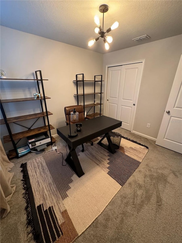 carpeted home office featuring a chandelier and a textured ceiling