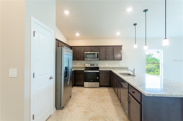 kitchen featuring light stone countertops, sink, hanging light fixtures, stainless steel appliances, and kitchen peninsula