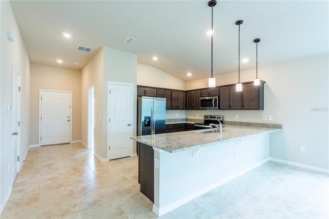 kitchen featuring light stone counters, kitchen peninsula, pendant lighting, lofted ceiling, and appliances with stainless steel finishes