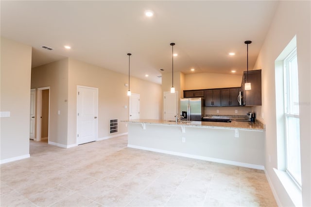 kitchen featuring light stone countertops, stainless steel fridge with ice dispenser, pendant lighting, vaulted ceiling, and dark brown cabinets