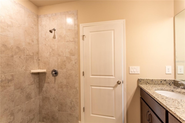 bathroom with vanity and tiled shower