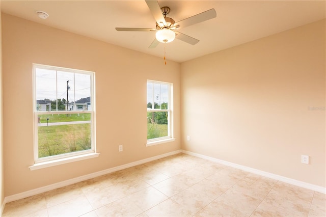 spare room with light tile patterned floors and ceiling fan