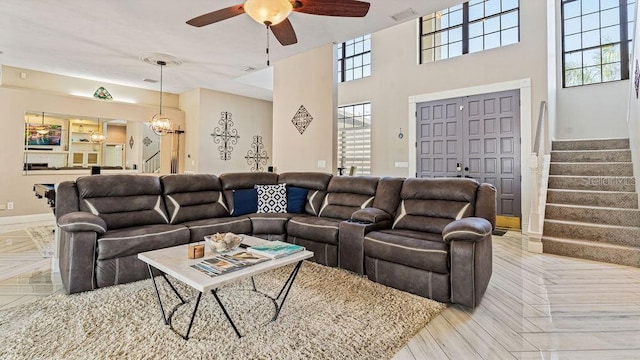 living room featuring ceiling fan with notable chandelier and a wealth of natural light