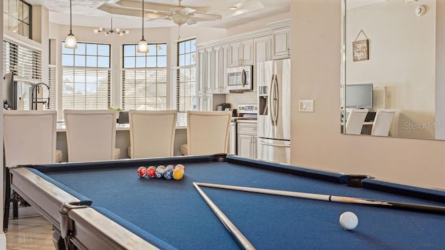 game room with light hardwood / wood-style flooring, a raised ceiling, ceiling fan, and billiards