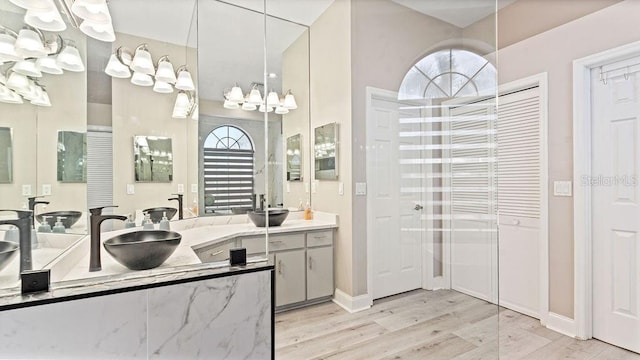 bathroom featuring vanity, hardwood / wood-style flooring, walk in shower, and a healthy amount of sunlight