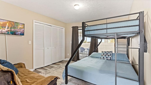 bedroom featuring a textured ceiling, light wood-type flooring, and a closet