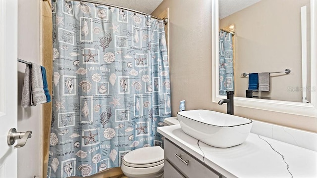 bathroom with vanity, toilet, a textured ceiling, and walk in shower