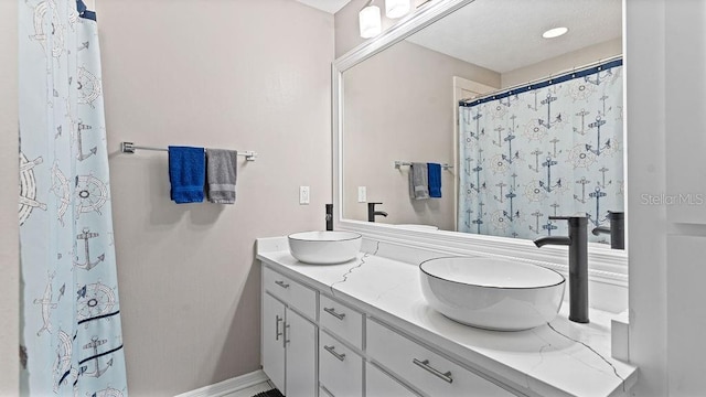 bathroom with a shower with shower curtain and vanity