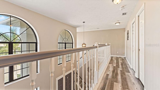 hall featuring wood-type flooring and a textured ceiling