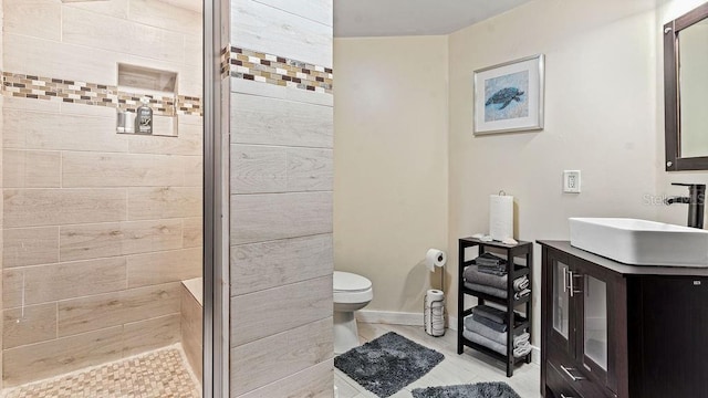 bathroom featuring tile patterned flooring, vanity, an enclosed shower, and toilet