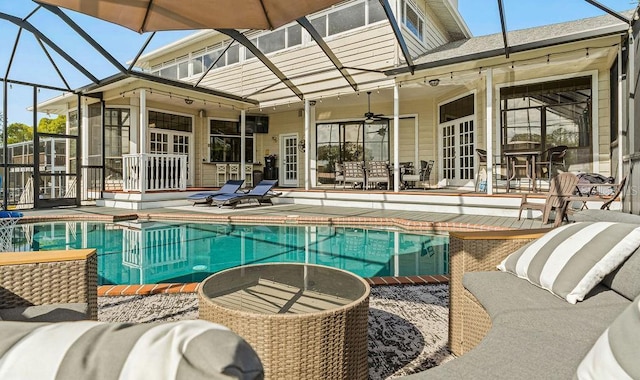 view of swimming pool with a patio, glass enclosure, and ceiling fan