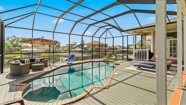 view of swimming pool featuring outdoor lounge area, glass enclosure, and a patio area