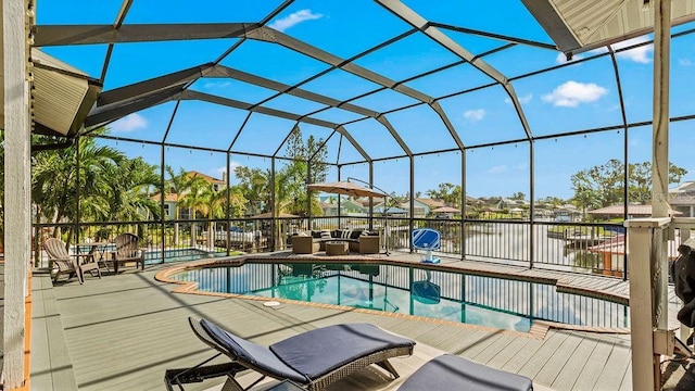 view of swimming pool featuring glass enclosure and a water view