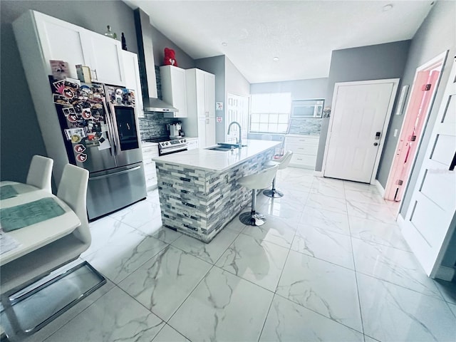 kitchen featuring a kitchen island with sink, a kitchen breakfast bar, sink, appliances with stainless steel finishes, and white cabinetry