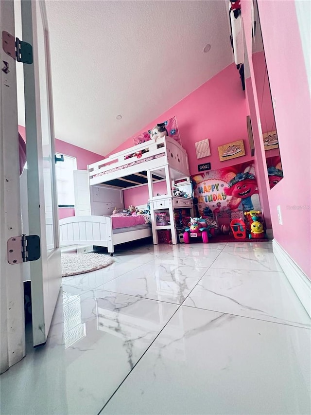 bedroom with lofted ceiling and a textured ceiling