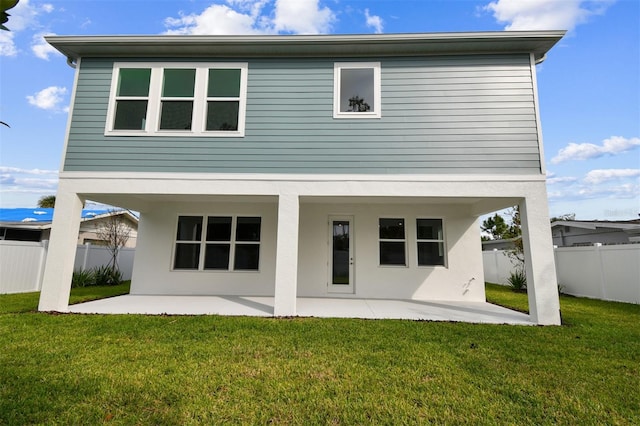 back of house featuring a lawn and a patio area