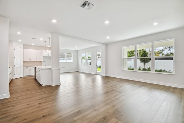 unfurnished living room featuring dark wood-type flooring and sink