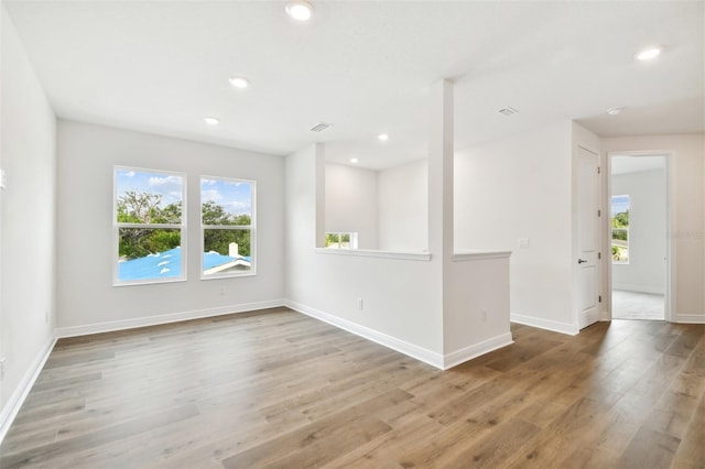 spare room with a wealth of natural light and light wood-type flooring