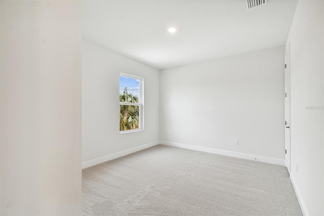 spare room featuring light carpet