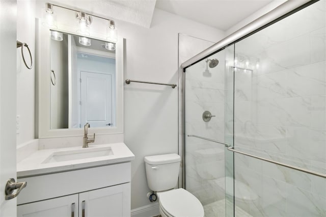 bathroom featuring vanity, toilet, and a shower with shower door