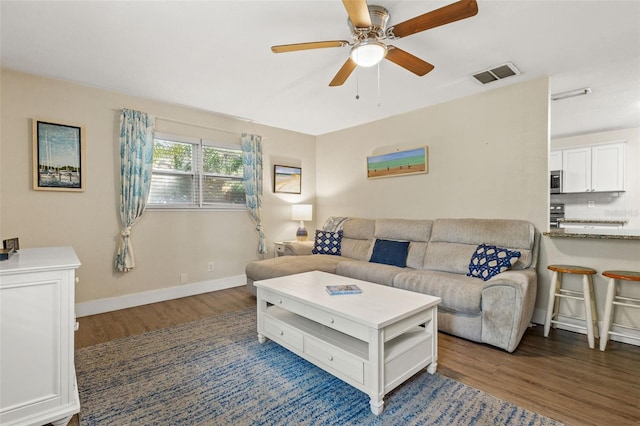 living room featuring dark hardwood / wood-style floors and ceiling fan