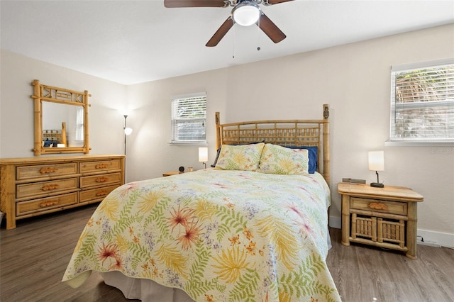 bedroom with ceiling fan, dark wood-type flooring, and multiple windows