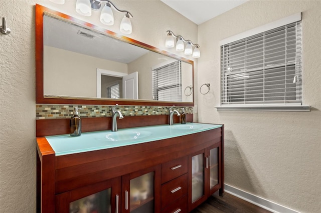 bathroom with tasteful backsplash, vanity, and wood-type flooring