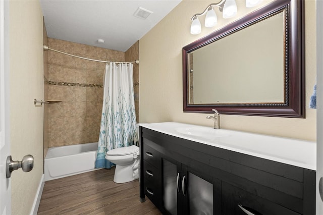 full bathroom featuring hardwood / wood-style floors, shower / bath combination with curtain, toilet, and vanity