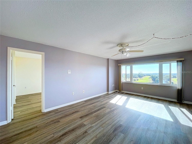 empty room featuring ceiling fan, dark hardwood / wood-style flooring, and a textured ceiling