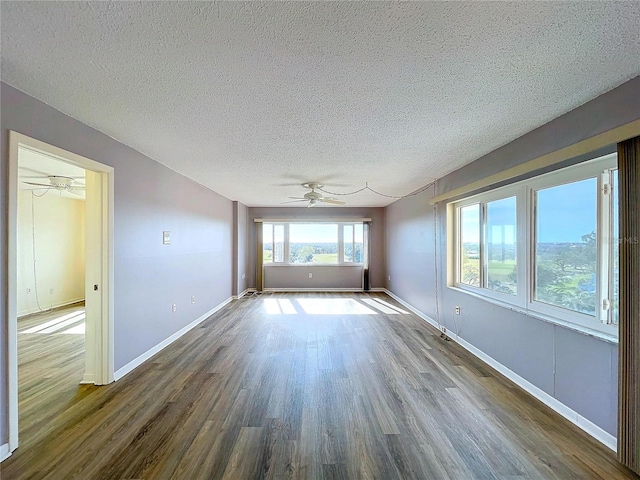 empty room with ceiling fan, hardwood / wood-style floors, and a textured ceiling