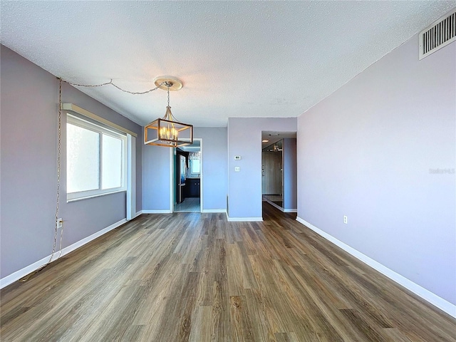 unfurnished living room featuring hardwood / wood-style floors and a textured ceiling