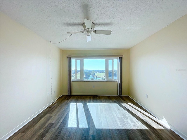 spare room featuring ceiling fan, dark wood-type flooring, and a textured ceiling