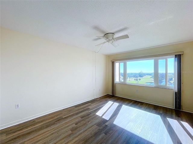 unfurnished room featuring dark hardwood / wood-style floors, ceiling fan, and a textured ceiling