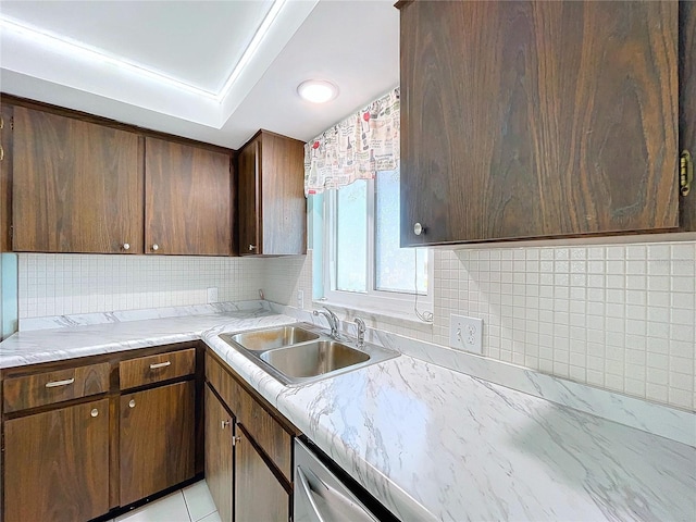 kitchen with sink, light tile patterned flooring, stainless steel dishwasher, and dark brown cabinets