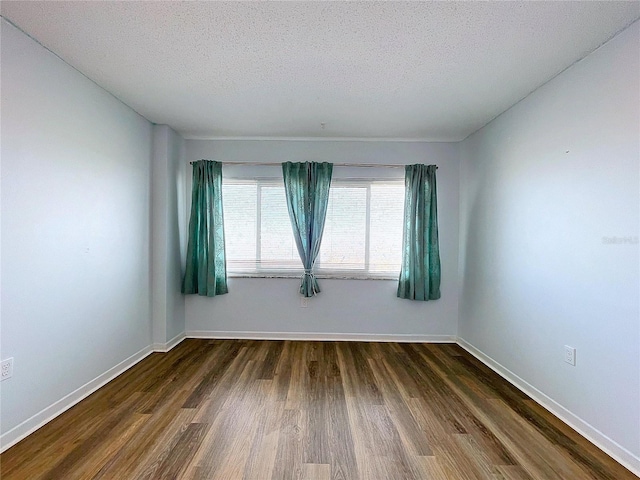 unfurnished room featuring a textured ceiling and dark wood-type flooring