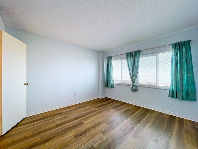 unfurnished room with hardwood / wood-style flooring and a textured ceiling